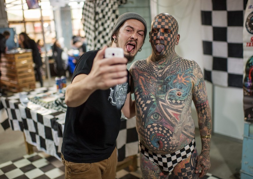 epa05319905 US tattoo star Matt Gone (R) poses for a selfie with a visitor during the Tattoo Collection Festival in Kiev, Ukraine, 20 May 2016. Matt Gone, often referred as &#039;Human Chequerboard&#0 ...