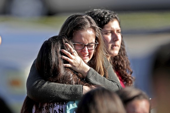 FILE - In this Wednesday, Feb. 14, 2018 file photo, students released from a lockdown embrace following a shooting at Marjory Stoneman Douglas High School in Parkland, Fla. A week after a shooter slau ...