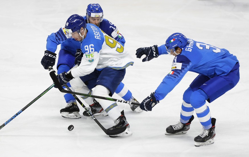 Kazakhstan&#039;s Alikhan Asetov, centre, challenges for the puck with Enrico Miglioranzi during the Ice Hockey World Championship group B match between Italy and Kazakhstan at the Arena in Riga, Latv ...