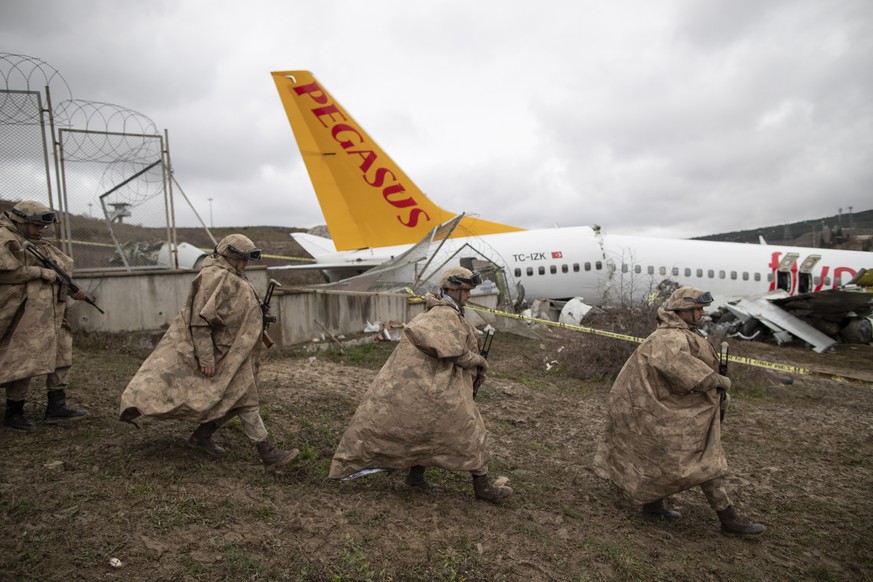 epaselect epa08196957 Turkish soldiers secure the wreckage 06 February 2020 after a Pegasus Airlines aircraft skidded off the Sabiha Goekcen airport runway in Istanbul, Turkey, 05 February 2020. Three ...