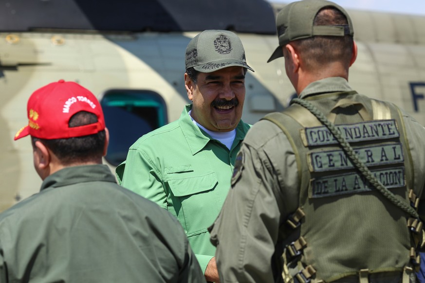 epa07330706 Handout picture made available by the Miraflores Palace which shows President of Venezuela Nicolas Maduro (C) during a visit to a military base, in Aragua, Venezuela, 29 January 2019. Duri ...