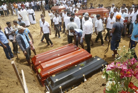 epaselect epa07522396 Relatives and friends burry the victims of a series of bomb blasts, at cemetery Don David Katuwapitiya in Colombo, Sri Lanka, 23 April 2019. According to police, at least 290 peo ...