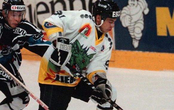 Der Zuercher Marc Haueter, Mitte, versucht sich im Spiel der ersten Runde der Eishockey NLA zwischen dem HC Gotteron und den ZSC Lions, am 20. September 1997 in Freiburg, gegen das Freiburger Russen-D ...