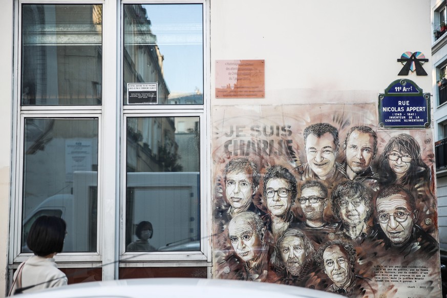 epa08640729 A woman looks at a paintings depicting Charlie Hebdo&#039;s killed cartoonists by French street artist Christian Guemy, outside the satirical .newspaper Charlie Hebdo&#039;s former office, ...