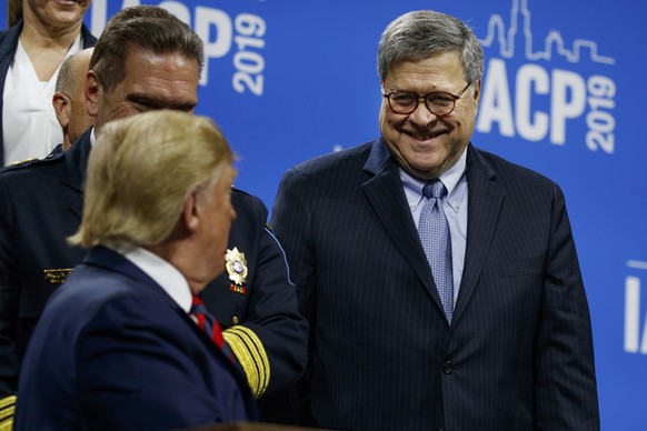 Attorney General William Barr smiles at President Donald Trump as he signs an executive order during the International Association of Chiefs of Police Annual Conference and Exposition, at the McCormic ...