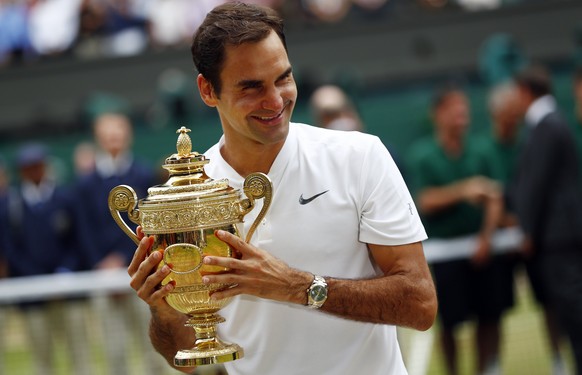 epa06091301 Roger Federer of Switzerland holds the championship trophy following his victory over Marin Cilic of Croatia in the men&#039;s final of the Wimbledon Championships at the All England Lawn  ...