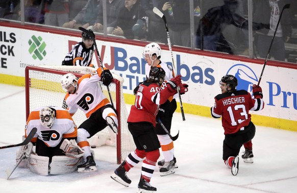 New Jersey Devils center Nico Hischier (13), of Switzerland, celebrates his goal with center Blake Coleman (40) during the third period of an NHL hockey game against the Philadelphia Flyers, Thursday, ...