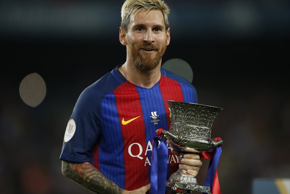FC Barcelona&#039;s Lionel Messi celebrates with the trophy after winning the Spanish Super Cup between FC Barcelona and Sevilla at the Camp Nou in Barcelona, Spain, Thursday, Aug. 18, 2016. (AP Photo ...