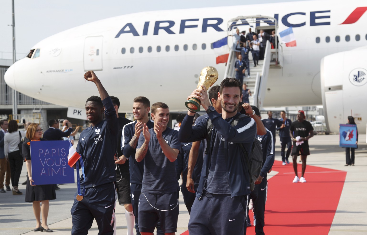 French goalkeeper Hugo Lloris holds the cup as the French soccer team arrives at Charles de Gaulle airport, Monday, July 16, 2018 in Roissy, north of Paris. France is preparing to welcome home the nat ...