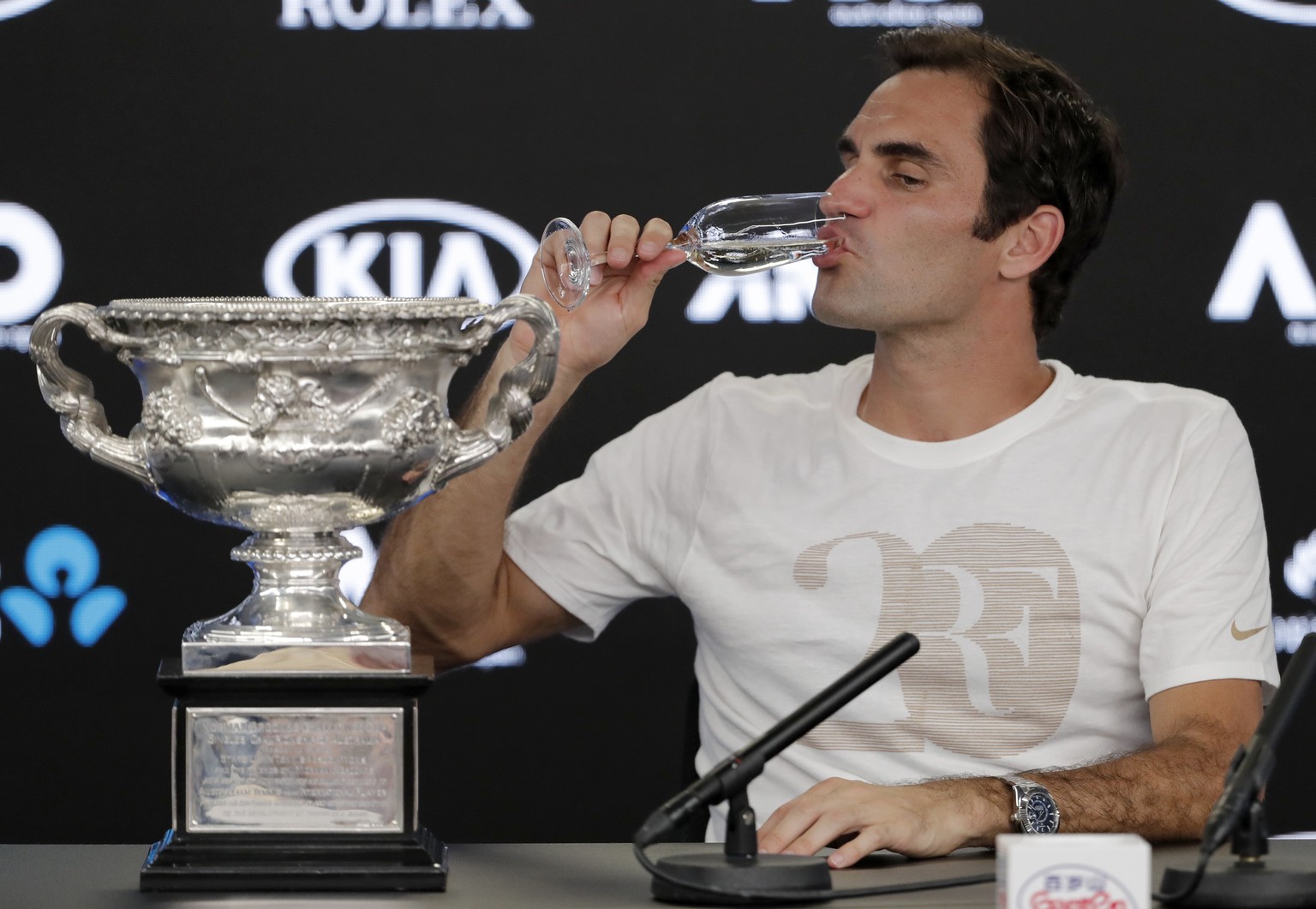 Switzerland&#039;s Roger Federer drinks a glass of champagne during a press conference after defeating Croatia&#039;s Marin Cilic in the men&#039;s singles final at the Australian Open tennis champion ...