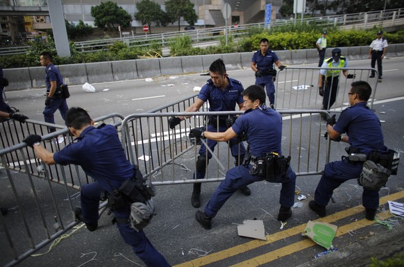 Polizisten entfernen Barrikaden.