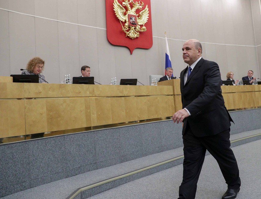 In this handout photo provided by The State Duma, The Federal Assembly of The Russian Federation, Russian Tax Service chief Mikhail Mishustin, who was nominated to replace Medvedev, leaves a podium af ...
