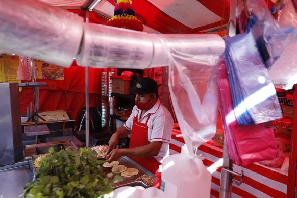 Biodegradable plastic bags, in compliance with a 2020 plastic bag ban, hang at a taco stand in central Mexico City, Friday, Jan. 1, 2021. The few street food vendors out working on New Year&#039;s Day ...