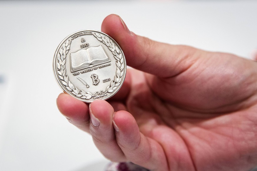 A man holds a Silver coin etched with the cryptographic information for digital Bitcoins in it during the &quot;Inside Bitcoins: The Future of Virtual Currency Conference&quot; in New York in this Apr ...
