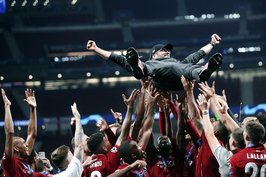 Liverpool coach Juergen Klopp is tossed in the air by teammates as they celebrate after defeating Tottenham Hotspur 2-0 in the Champions League final soccer match at the Wanda Metropolitano Stadium in ...