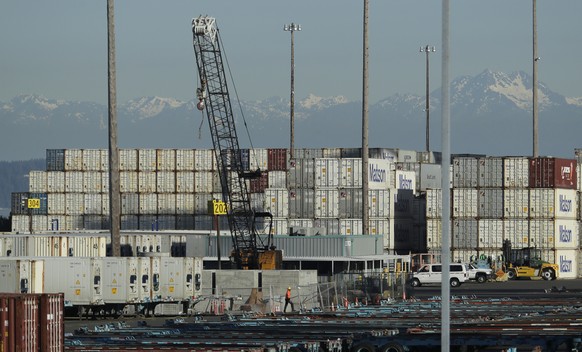 FILE - In this May 10, 2019 file photo, a worker walks near truck trailers and cargo containers at the Port of Tacoma in Tacoma, Wash. Hundreds of businesses, trade groups and individuals have written ...