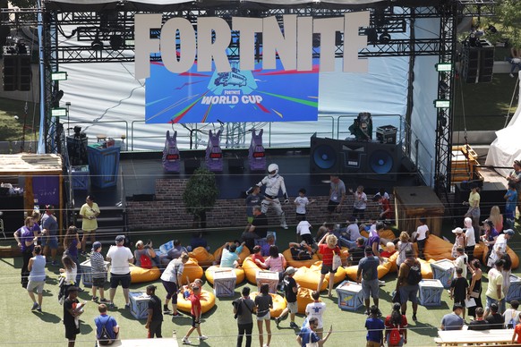 epa07746751 A person dressed as a Fortnite character dances with children and adults during the final of the Solo competition at the 2019 Fortnite World Cup at Flushing Meadows Arthur Ashe stadium in  ...