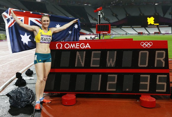 epa03349064 Sally Pearson of Australia poses next to the time board showing her new Olympic record after she won the 100m Hurdles final at the London 2012 Olympic Games Athletics, Track and Field even ...
