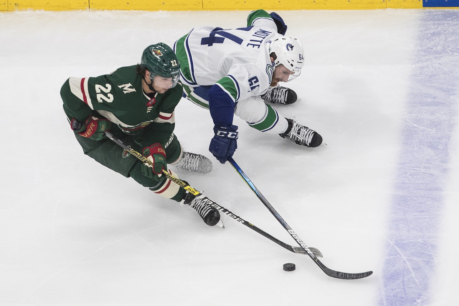 Minnesota Wild&#039;s Kevin Fiala (22) and Vancouver Canucks&#039; Tyler Motte (64) battle for the puck during the first period in an NHL hockey game in Edmonton, Alberta, Thursday Aug. 6, 2020. (Jaso ...