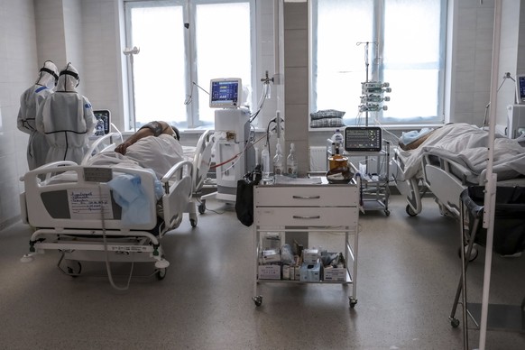 In this photo taken on Saturday, May 2, 2020, doctors attend to a patient inside the intensive care unit for people infected with the new coronavirus, at a hospital in Moscow, Russia. A Russian epidem ...