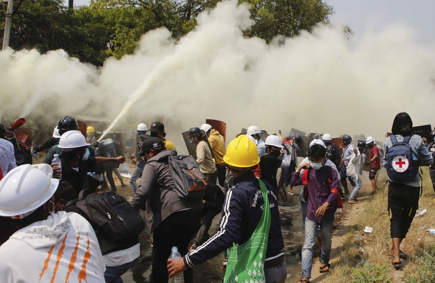Anti-coup protesters discharge fire extinguishers to counter the impact of the tear gas fired by police during a demonstration in Naypyitaw, Myanmar, Monday, March 8, 2021. Myanmar security forces are ...