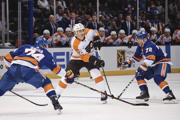 New York Islanders&#039; Luca Sbisa, left, and Stephen Gionta, right, go for the puck against Philadelphia Flyers&#039; Nicolas Aube-Kubel, during the first period of a preseason NHL hockey game in Ne ...