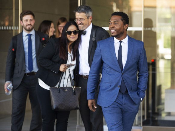 Rapper Marcus Gray, right, smiles as his attorney, Michael A. Kahn, second from right, congratulates Gray&#039;s wife, Crystal, as they leave the federal courthouse in Los Angeles, Thursday, Aug. 1, 2 ...