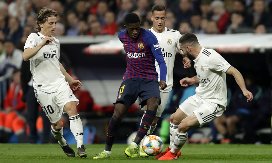 Barcelona forward Ousmane Dembele, center, controls the ball as Real defender Dani Carvajal, right, and midfielder Luka Modric try to stop him during the Copa del Rey semifinal second leg soccer match ...