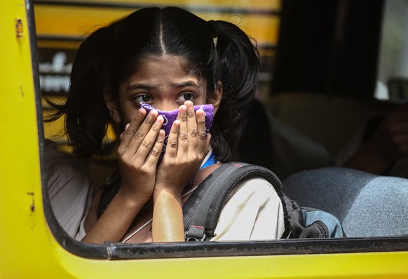 epaselect epa08288441 An Indian girl student covers her face as a precaution against the coronavirus outbreak, in Mumbai, India, 12 March 2020. According to media reports, more than 70 people in India ...