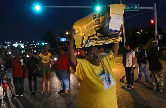 Sharon Cowan chants as she marches Tuesday, Aug. 9, 2016, in Ferguson, Mo., on the second anniversary of the death of Michael Brown, an unarmed black 18-year-old who was shoot by a white police office ...