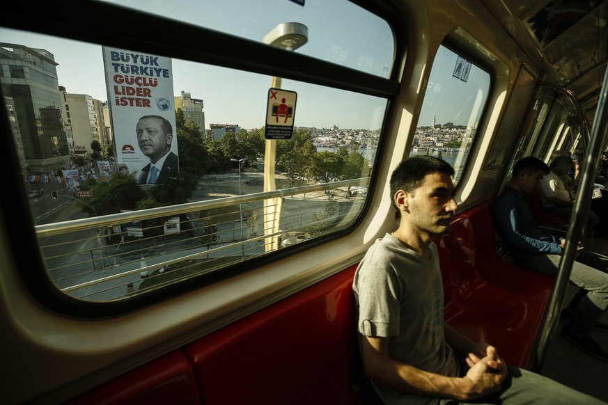 Commuters on a metro carriage pass a poster of Turkey&#039;s President Recep Tayyip Erdogan, in Istanbul, Friday, June 15, 2018. Turkey holds parliamentary and presidential elections on June 24, 2018, ...
