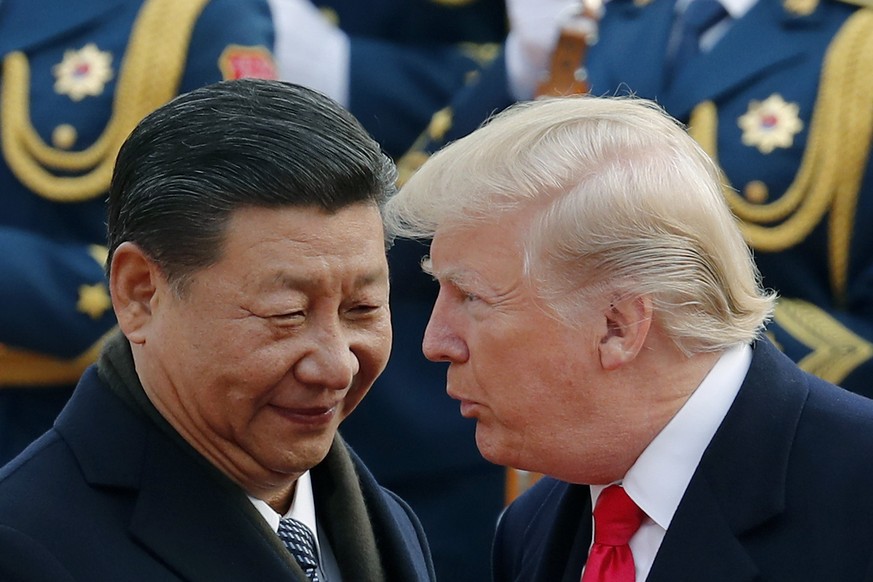 FILE - In this Nov. 9, 2017, file photo, U.S. President Donald Trump, right, chats with Chinese President Xi Jinping during a welcome ceremony at the Great Hall of the People in Beijing. The United St ...