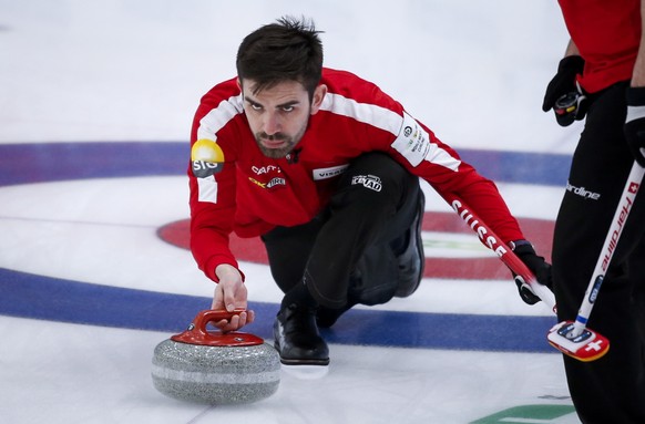 Switzerland skip Peter De Cruz makes a shot against China during a match at the men&#039;s World Curling Championships in Calgary, Alberta, Friday, April 9, 2021. (Jeff McIntosh/The Canadian Press via ...