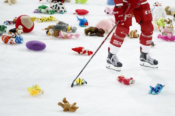 Le defenseur lausannois John Gobbi evacue des peluches de la glace apres un lancer de jouets a but caritatif lors de la rencontre du championnat suisse de hockey sur glace de National League entre le  ...