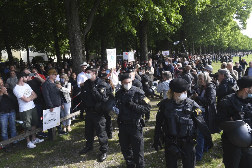 Police officers observe participants of a demonstration against the anti-Corona measures of politics at the edge of the Theresienwiese in Munich, Germany, Saturday, May 16, 2020. (Felix Hoerhager/dpa  ...
