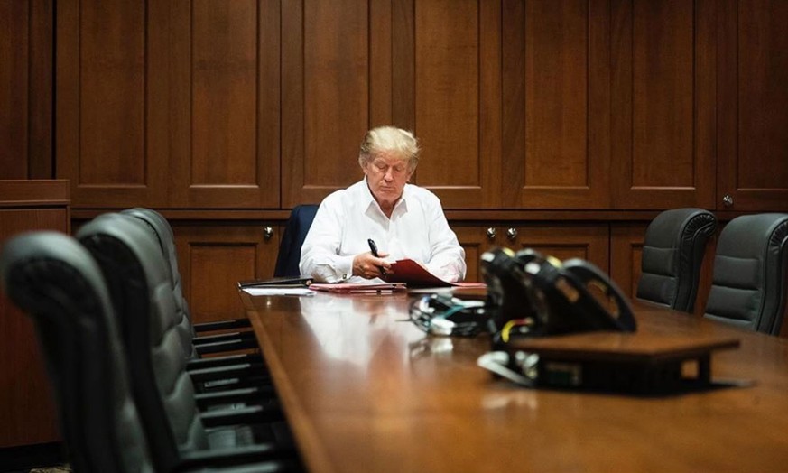 epa08719254 A handout image made available by the White House showing US President Donald Trump working in a conference room while receiving treatment after testing positive for the coronavirus diseas ...