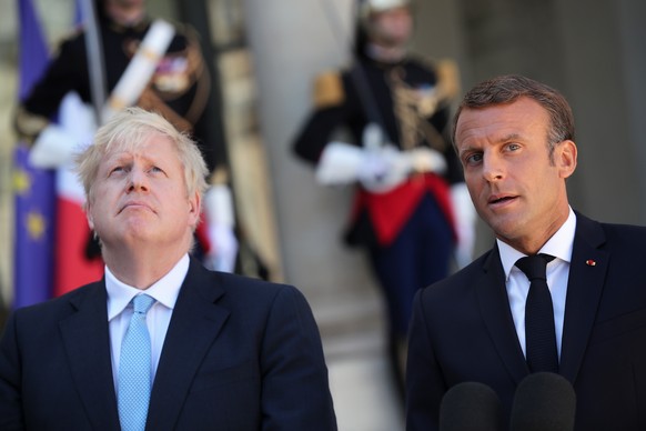 epaselect epa07785596 French President Emmanuel Macron (R) and British Prime Minister Boris Johnson (L) give a press conference prior to their meeting at the Elysee Palace in Paris, France, 22 August  ...
