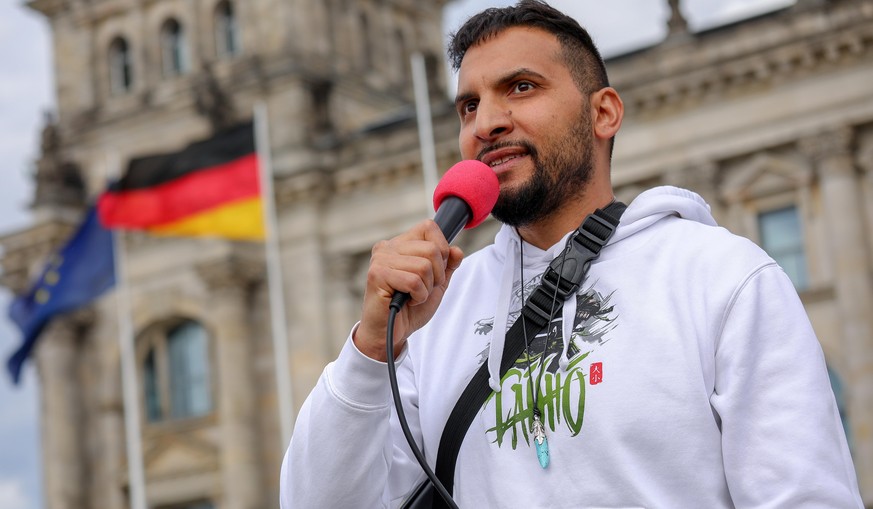 epa08426170 German vegan chef Attila Hildmann speaks during a demonstration in front of the Reichstag building, seat of the German parliament the Bundestag in Berlin, Germany, 16 May 2020. A series of ...