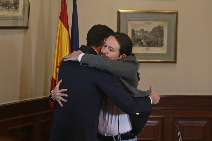 Spain&#039;s caretaker Prime Minister Pedro Sanchez, left, and Podemos party leader Pablo Iglesias hug after signing an agreement at the parliament in Madrid, Spain, Tuesday, Nov. 12, 2019.The leaders ...