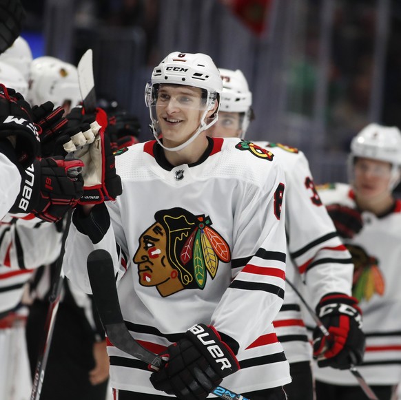 FILE - Chicago Blackhawks left wing Dominik Kubalik, center, smiles as he is congratulated while passing the team box after scoring the go-ahead goal against the Colorado Avalanche during the third pe ...