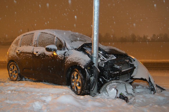 HANDOUT - Ein Auto nach einer Kollision mit einem Pfosten auf der Schochenmuehlestrass in Baar ZG, am Montag, 26. Januar 2015. Wegen winterlicher Strassenverhaeltnissen ist es auf dem Zuger Kantonsgeb ...