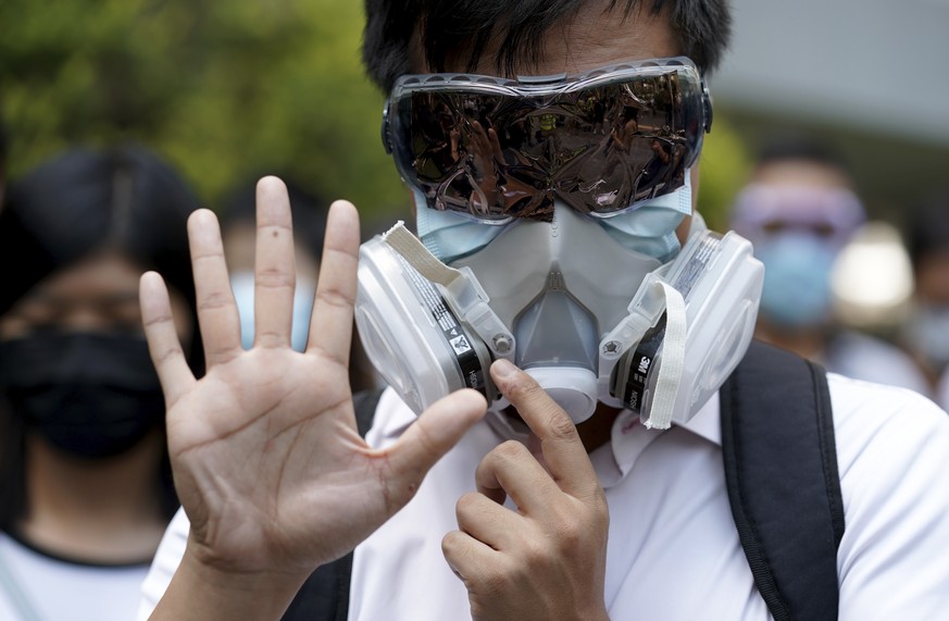A protester wears a gas mask and holds up his hand to represent the protester&#039;s five demands in Hong Kong Friday, Oct. 4, 2019. Hong Kong pro-democracy protesters marched in the city center ahead ...
