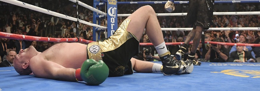 Tyson Fury, of England, lies on the canvas after being knocked down by Deontay Wilder during the 12th round of a WBC heavyweight championship boxing match Saturday, Dec. 1, 2018, in Los Angeles. (AP P ...