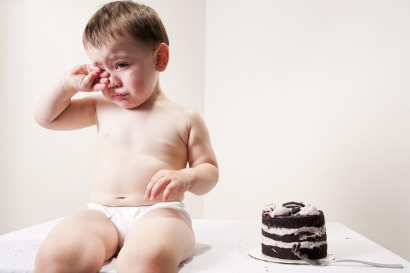 Weinen Baby - Stock-Fotografie
A baby wiping his eyes from crying. There is a three layered chocolate cake next to him with a fork.