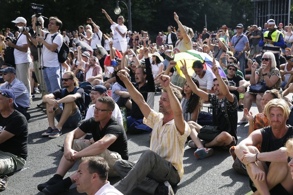 Protestors sit on the ground and shout slogans after the police declared the end of a protest, in Berlin, Germany, Saturday, Aug. 1, 2020. Thousands converged in Berlin to protest Germany&#039;s coron ...