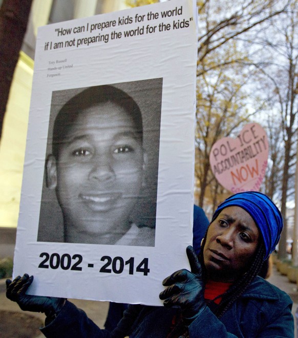 FILE - In this Dec. 1, 2014, file photo, Tomiko Shine holds up a picture of Tamir Rice, a 12-year-old boy fatally shot Nov. 22, 2014, by a rookie police officer in Cleveland, Ohio, during a protest in ...