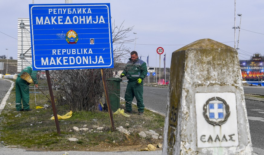 epa07363609 Workers clean the area around a Greek border stone and a sign reading &#039;Republic of Macedonia&#039; at the border crossing between the FYR of Macedonia and Greece in Bogorodica, 11 Feb ...