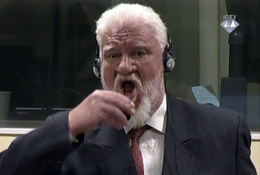 In this photo provided by the ICTY on Wednesday, Nov. 29, 2017, Slobodan Praljak brings a bottle to his lips, during a Yugoslav War Crimes Tribunal in The Hague, Netherlands. Praljak yelled, &quot;I a ...