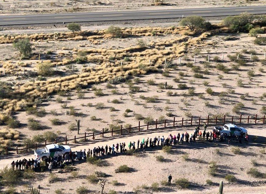 File - In this Thursday, Feb. 7, 2019, file aerial image released by the U.S. Customs and Border Protection, migrants, apprehended after illegally crossing along the U.S.-Mexico border near Lukeville, ...