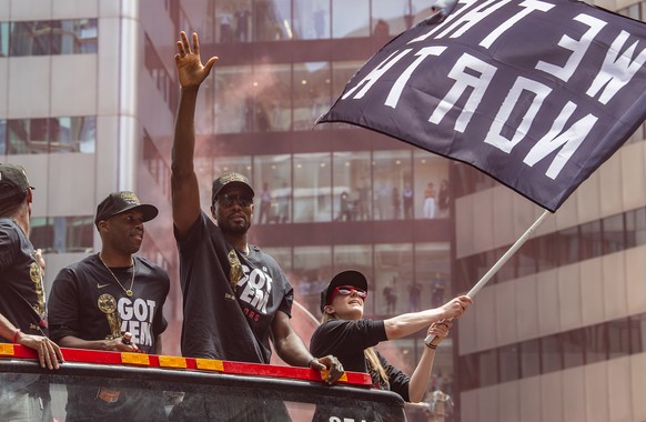 epa07654661 Toronto Raptors guard Jodie Meeks (L) and forward Serge Ibaka (C) celebrate aboard an open bus during a victory parade through downtown Toronto, Canada, 17 June 2019. The 2019 NBA Champion ...